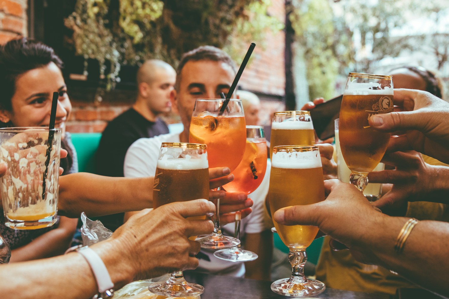 Friends raising their glasses in a toast at a restaurant patio